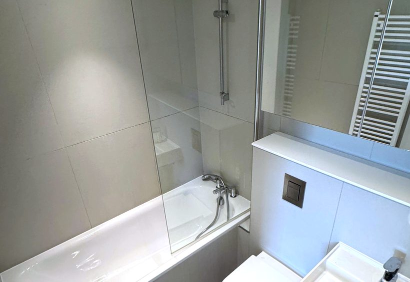 Bathroom with the bath, glass screen and basin cleaned and descaled