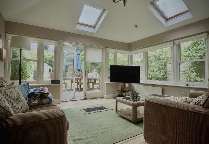 Sunroom lined with garden windows, wooden floor and rug cleaned throughout